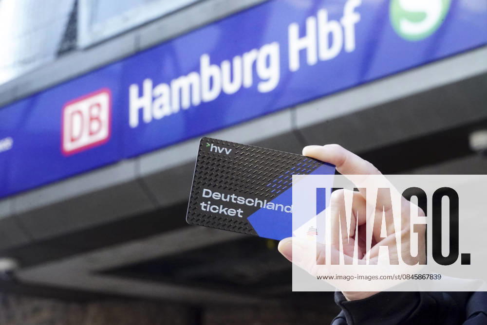 Cntv: Deutschlandtiket in der Hand vor HVV Bus und Bahnen Deutscxhe Bahn Deutschlandticket ist ein monatliches Abonnement für den gesamten deutschen ÖPNV OEPNV oeffentlichen Nahverkehr Busse, Straßenbahnen, U-Bahnen, S-Bahnen, REs, RB). Es kostet seit Januar 2026 63,00 Euro pro Monat und Fahrgast und gilt deutschlandweit Hamburg Germany