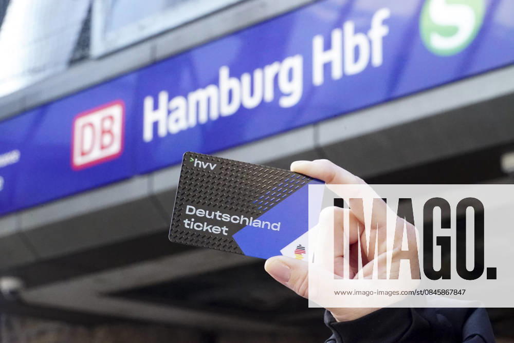 Cntv: Deutschlandtiket in der Hand vor HVV Bus und Bahnen Deutscxhe Bahn Deutschlandticket ist ein monatliches Abonnement für den gesamten deutschen ÖPNV OEPNV oeffentlichen Nahverkehr Busse, Straßenbahnen, U-Bahnen, S-Bahnen, REs, RB). Es kostet seit Januar 2026 63,00 Euro pro Monat und Fahrgast und gilt deutschlandweit Hamburg Germany