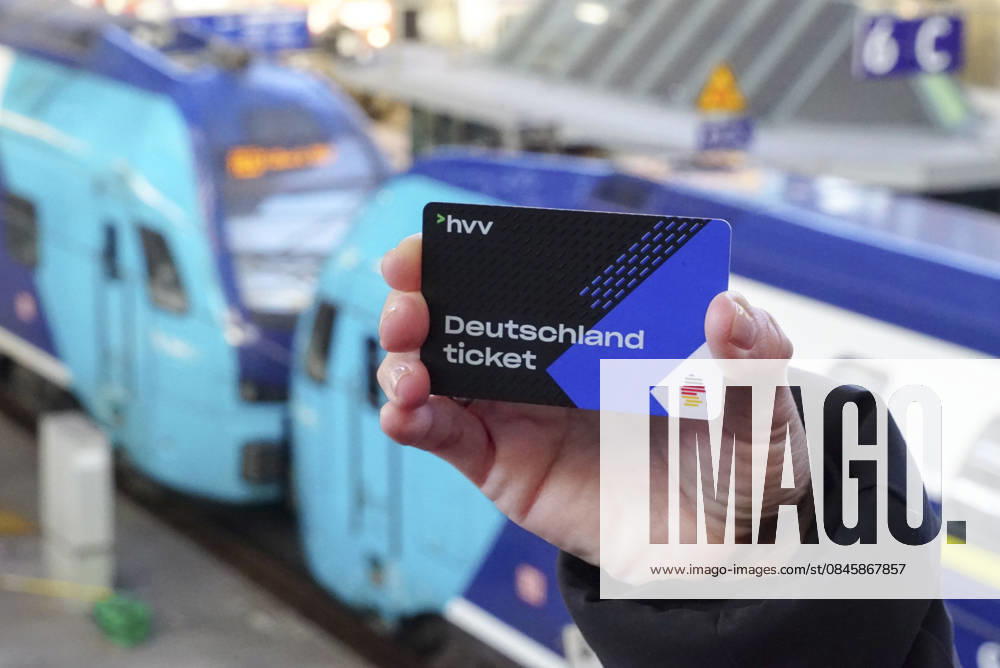 Cntv: Deutschlandtiket in der Hand vor HVV Bus und Bahnen Deutscxhe Bahn Deutschlandticket ist ein monatliches Abonnement für den gesamten deutschen ÖPNV OEPNV oeffentlichen Nahverkehr Busse, Straßenbahnen, U-Bahnen, S-Bahnen, REs, RB). Es kostet seit Januar 2026 63,00 Euro pro Monat und Fahrgast und gilt deutschlandweit Hamburg Germany