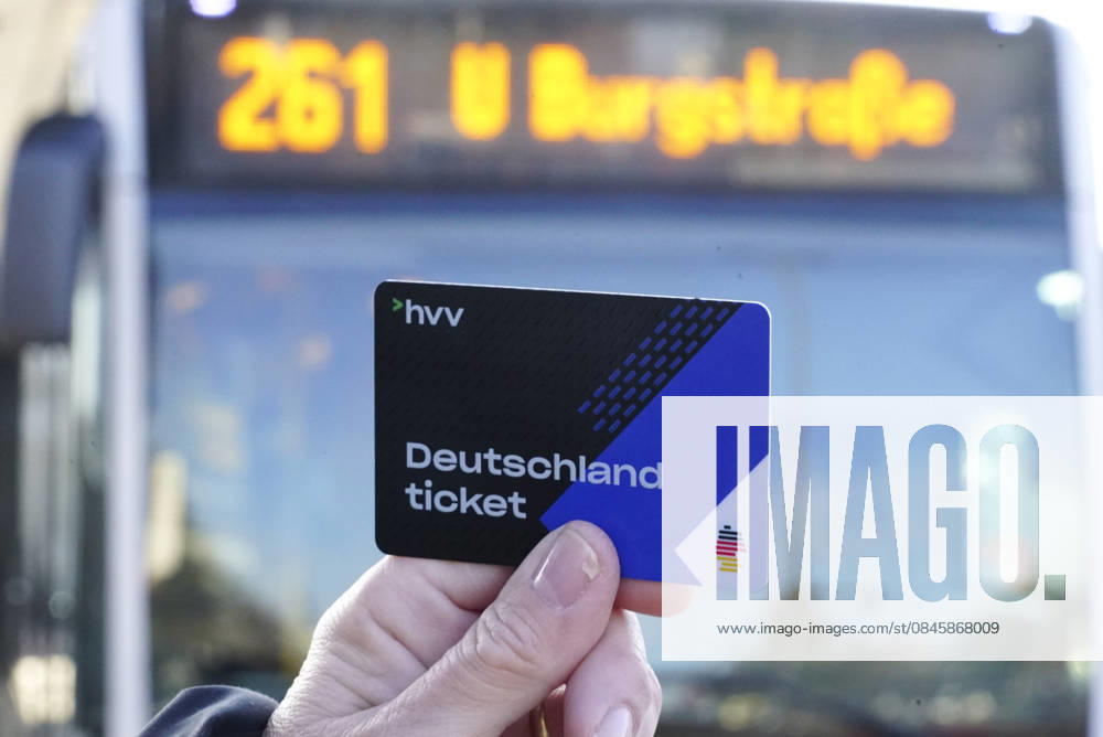 Cntv: Deutschlandtiket in der Hand vor HVV Bus und Bahnen Deutscxhe Bahn Deutschlandticket ist ein monatliches Abonnement für den gesamten deutschen ÖPNV OEPNV oeffentlichen Nahverkehr Busse, Straßenbahnen, U-Bahnen, S-Bahnen, REs, RB). Es kostet seit Januar 2026 63,00 Euro pro Monat und Fahrgast und gilt deutschlandweit Hamburg Germany