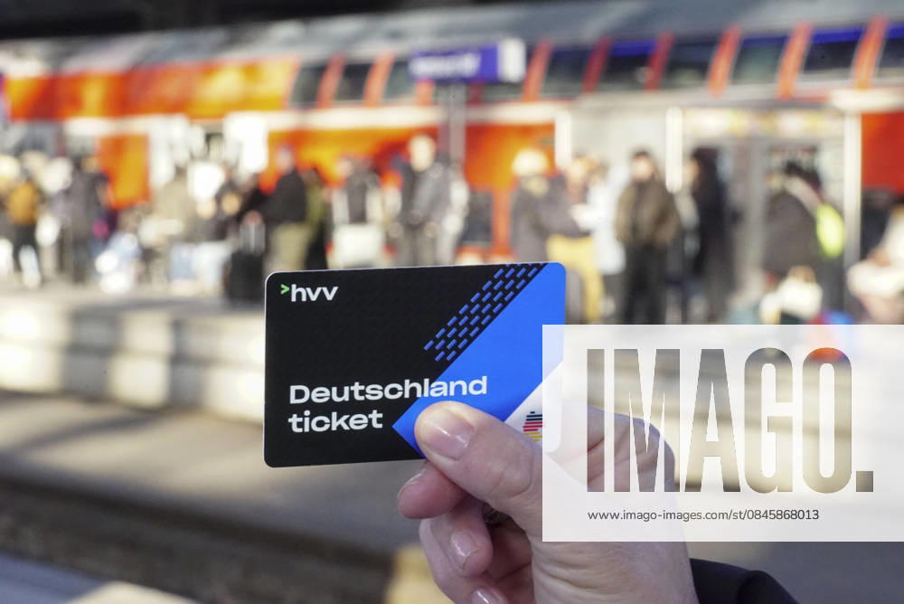 Cntv: Deutschlandtiket in der Hand vor HVV Bus und Bahnen Deutscxhe Bahn Deutschlandticket ist ein monatliches Abonnement für den gesamten deutschen ÖPNV OEPNV oeffentlichen Nahverkehr Busse, Straßenbahnen, U-Bahnen, S-Bahnen, REs, RB). Es kostet seit Januar 2026 63,00 Euro pro Monat und Fahrgast und gilt deutschlandweit Hamburg Germany
