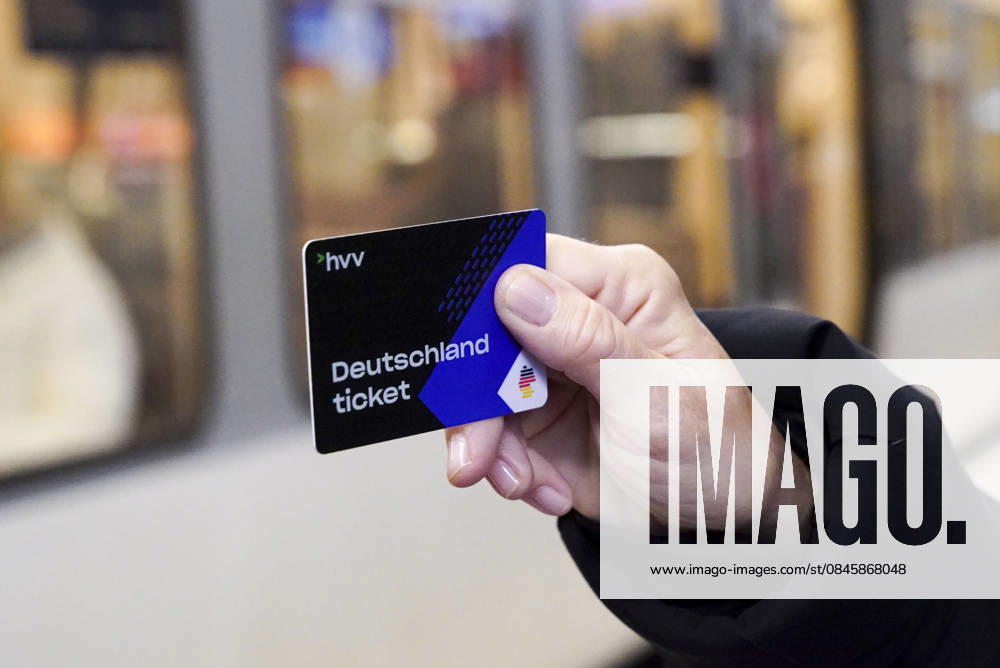 Cntv: Deutschlandtiket in der Hand vor HVV Bus und Bahnen Deutscxhe Bahn Deutschlandticket ist ein monatliches Abonnement für den gesamten deutschen ÖPNV OEPNV oeffentlichen Nahverkehr Busse, Straßenbahnen, U-Bahnen, S-Bahnen, REs, RB). Es kostet seit Januar 2026 63,00 Euro pro Monat und Fahrgast und gilt deutschlandweit Hamburg Germany
