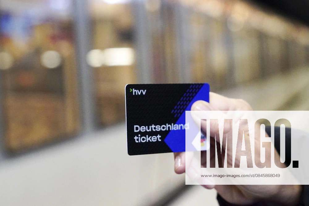 Cntv: Deutschlandtiket in der Hand vor HVV Bus und Bahnen Deutscxhe Bahn Deutschlandticket ist ein monatliches Abonnement für den gesamten deutschen ÖPNV OEPNV oeffentlichen Nahverkehr Busse, Straßenbahnen, U-Bahnen, S-Bahnen, REs, RB). Es kostet seit Januar 2026 63,00 Euro pro Monat und Fahrgast und gilt deutschlandweit Hamburg Germany