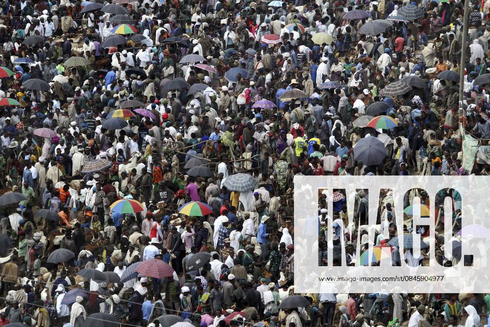 Dichte Menschenmenge mit bunten Schirmen auf einem belebten Markt, Lalibela, Äthiopien Dense crowd with colorful umbrellas at a busy market, Lalibela, Ethiopia