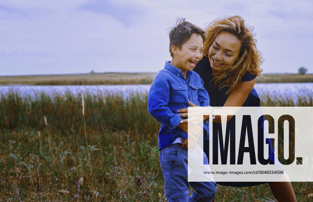 Mother and boy with Down syndrome laughing together outdoors in nature model released, Symbolfoto, AZF01100