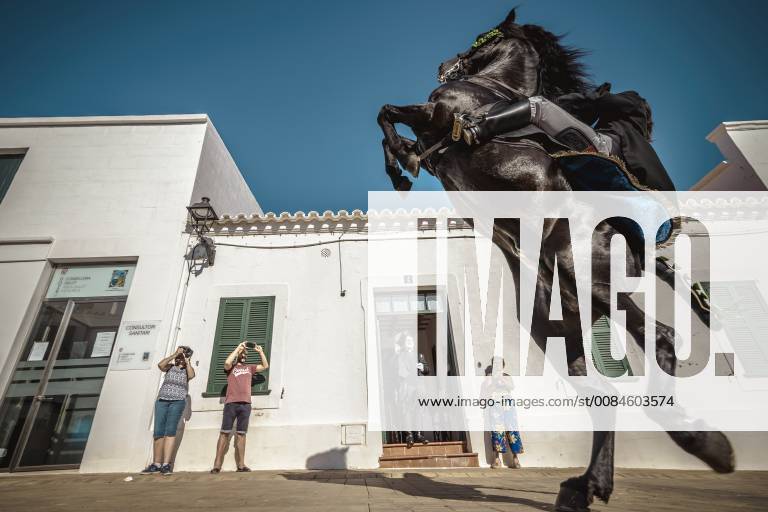 Fornells, Balearic Islands, Spain - A caixer (horse rider) rears up on his horse passing the greeting preast in his house before incorporating him into the cavalcade through the village prior to the traditional Jaleo at the Sant Antoni Festival in Fornells Fornells Spain - ZUMAo105 20180721_zap_o105_014