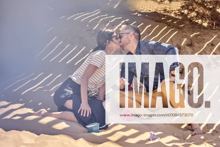 IMAGO Creative, Sommer, Schatten-Plätze bei Hitze Couple kissing in shadow on the beach model released Symbolfoto BEF00129