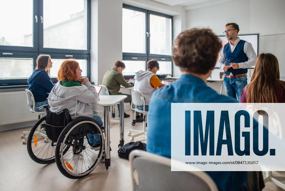 Inclusive classroom scene with student using wheelchair. Inclusive classroom scene with student using wheelchair.Accessible school environment. model released