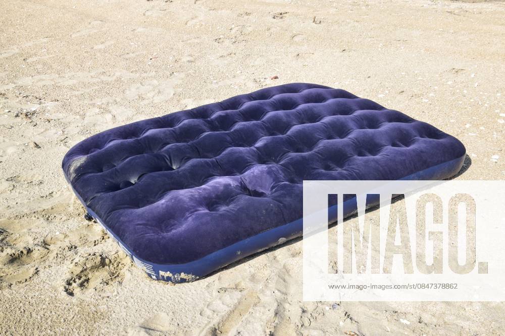 Blaue aufblasbare Matratze, die im Teich schwimmt. Eine aufblasbare Matratze am Strand Blue inflatable mattress swimming in the pond. An inflatable mattress on the beach