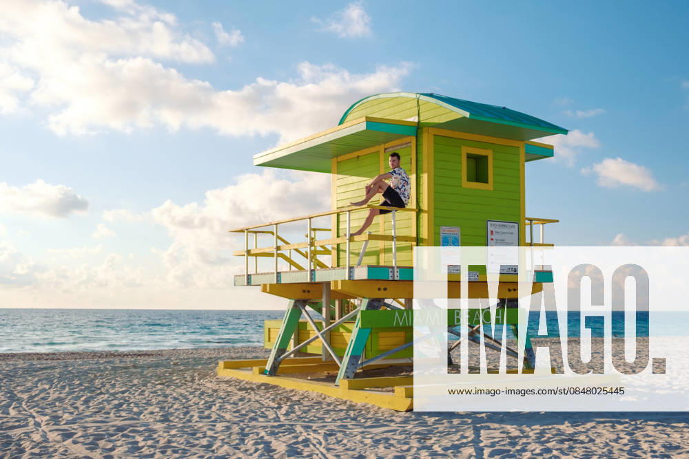 Leuchtend gelber Rettungsschwimmerturm am Miami Beach an einem sonnigen Tag Enjoy a sunny day at Miami Beach with its iconic bright yellow lifeguard tower. The vibrant colors and serene ocean view create an inviting atmosphere for beachgoers seeking relaxation and fun. (License=RF) ,model released, Symbolfoto