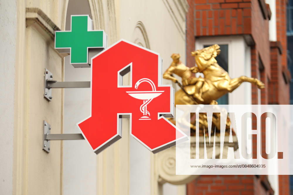 Ein Apotheken-A hängt an der Fassade einer Apotheke in der Langen Reihe. Dahinter ist eine Goldskulptur an die Fassade angebracht worden. St. Georg Hamburg