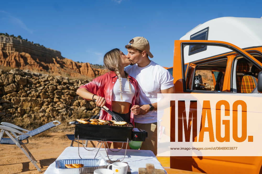 Couple enjoying a romantic cookout in Red Canyon Spain A couple shares a loving moment while cooking outdoors with a scenic view of Red Canyon, Spain in the background. An expression of love and adventure in a picturesque setting. Model Released JoseLuisCarrascosa_ID32450_1105872_185