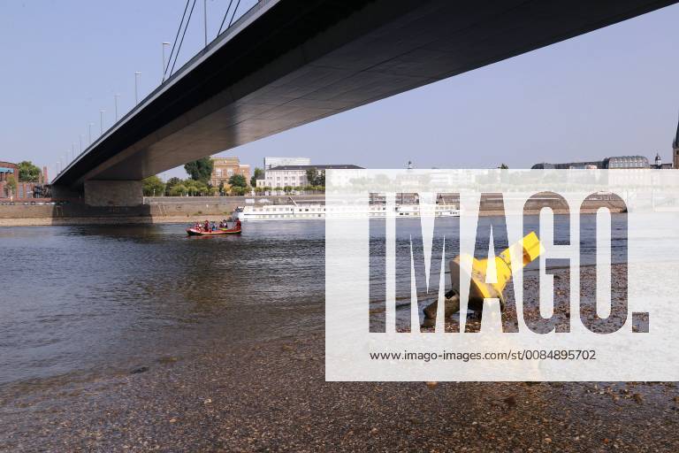 Der Rhein in Düsseldorf wird aufgrund der anhaltenden Trockenheit immer schmaler. Die Bunen am Ufer under Oberkasseler Brücke sind komplett zusehen. Der Weg zum Wasser führt die wenigen Badegäste über eine ausgetrocknete Schotterpiste. Heutiger Pegelstand 84 cm. Durch den Sog der Frachter zieht sich das Rheinwasser kurz zurück, um dann wieder zurückzulaufen.
