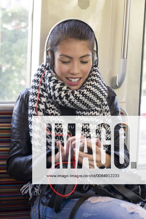 Young woman using smartphone on subway train