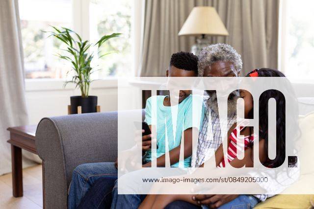 Senior African American man and his grandchildren enjoying their time at home Senior African American man and his grandchildren enjoying their time at home together, sitting on a couch, embracing, smiling, using a smartphone, model released, , property released, Cape Town, South Africa, 19.02.2020, 1340051.jpg, people,family,grandfather,granddad,granddaughter,grandson,siblings,brother,sister,childhood,together,closeness,interacting,sitting,couch,holding,using,phone,mobile phone,smartphone,connection,communication,real people,home,house,domestic life,lifestyle,enjoying,free time,leisure,relaxing,weekend,summer,sunny,love Child,Girl,Female,Mixed-Race,Boy,Male,Black,Mid Adult,Man Indoors,Side view,Day,Three Quarter Length