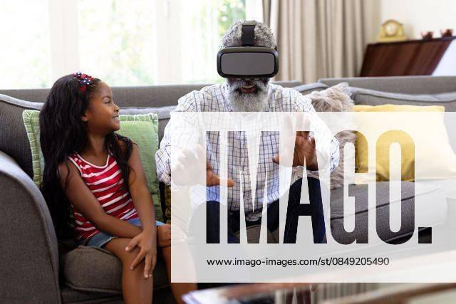 Senior African American man and his granddaughte Using vr headset Senior African American man and his granddaughter enjoying their time at home together, sitting on a couch, wearing a VR headset, model released, , property released, Cape Town, South Africa, 19.02.2020, 1340097.jpg, people,family,grandfather,granddad,granddaughter,childhood,together,closeness,interacting,sitting,couch,happy,smiling,wearing,using,vr,virtual reality,headset,connection,communication,real people,home,house,domestic life,lifestyle,enjoying,free time,leisure,relaxing,weekend,summer,sunny,love Child,Girl,Female,Mixed-Race,Mid Adult,Man,Male,Black Indoors,Front view,Day,Three Quarter Length