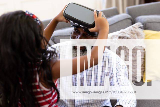 Senior African American man and his granddaughter Using vr headset Senior African American man and his granddaughter enjoying their time at home together, sitting on a couch, wearing a VR headset, model released, , property released, Cape Town, South Africa, 19.02.2020, 1340098.jpg, people,family,grandfather,granddad,granddaughter,childhood,together,closeness,interacting,sitting,couch,happy,smiling,wearing,using,vr,virtual reality,headset,connection,communication,real people,home,house,domestic life,lifestyle,enjoying,free time,leisure,relaxing,weekend,summer,sunny,love Child,Girl,Female,Mixed-Race,Mid Adult,Man,Male,Black Indoors,Front view,Looking at camera,Day,Half length