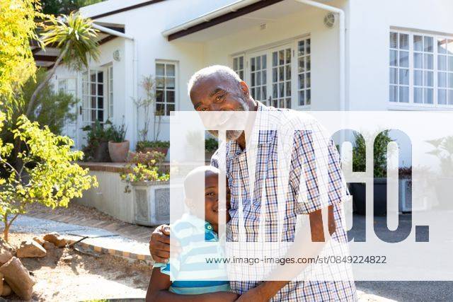 Senior African American man and his grandson spending time together in their garden on a sunny day Senior African American man and his grandson spending time together in their garden on a sunny day, smiling and looking straight into a camera., model released, , property released, Cape Town, South Africa, 24.01.2020, 1352225.jpg, people,real people,home,domestic life,lifestyle,free time,leisure,relaxing,happy,enjoying,smiling,summer,garden,backyard,sunny,hobby,heathy,nature,heathy lifestyle,active seniors,retirement,interacting,togetherness,closeness,grandfather,grandson,playing,fun,embracing,hugging,portrait Child,Boy,Male,Black,Senior,Elderly,Man,Mixed-Race Outdoors,Front view,Focus on Foreground,Looking at camera,Two objects,Day,Half len