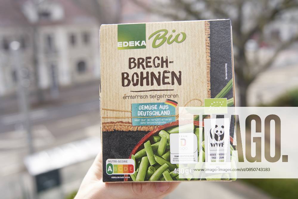 Verpackung von Edeka Bio Brechbohnen mit WWF-Logo und Straßenansicht im verschwommenen Hintergrund, tiefgekühlt, geforen, erntefrisch tiefgefroren, eingeforen, lange haltbar, haltbarmachung, gesund, Tiefkühlprodukt, Produkt, biologisch Packaging of Edeka organic beans with WWF logo and street view in a blurred background, frozen, freshly harvested frozen, frozen, sealed, long shelf life, shelf life, healthy, frozen product, organic