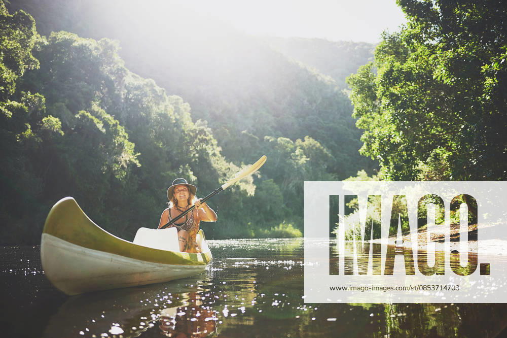Travel, kayak and smile with woman in lake for forest adventure, journey or eco tourism. Wildlife expedition, canoe boat and weekend break with person rowing in nature for summer vacation and explore. model released property released