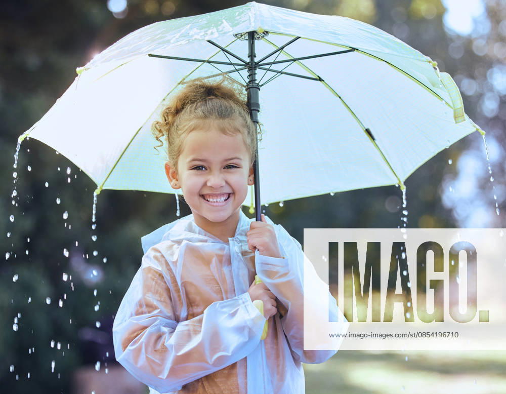 This is the best kind of weather. a little girl playfully standing in the rain holding her umbrella (License=RF) ,model released, Symbolfoto