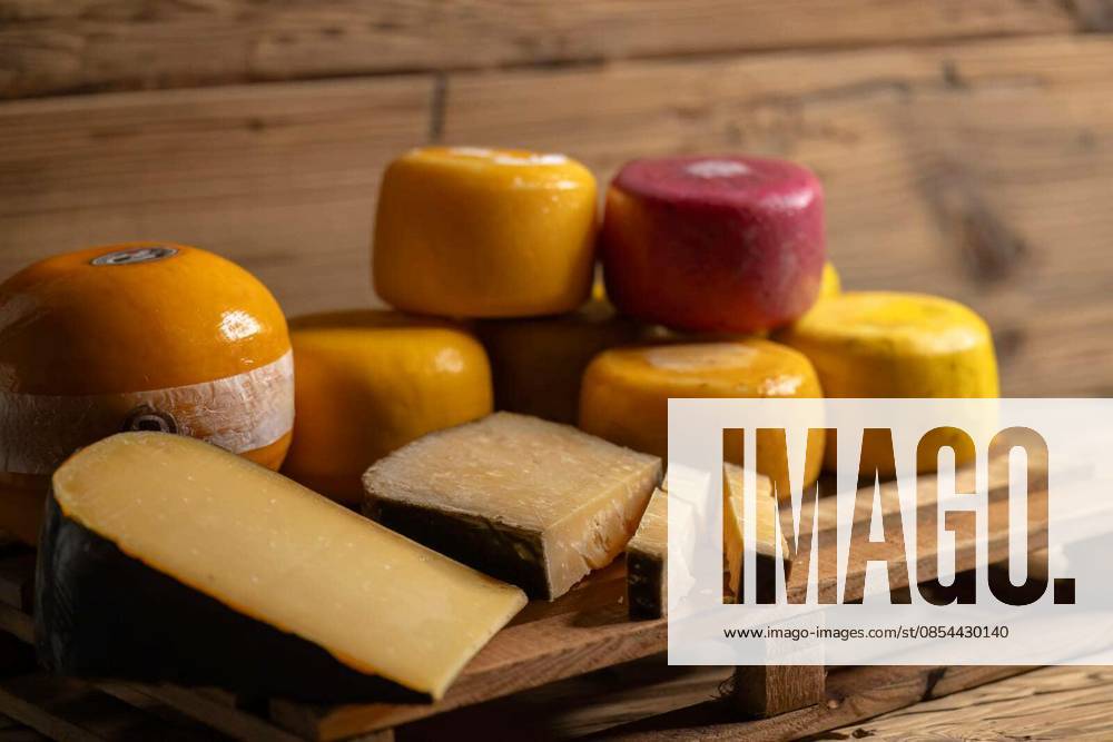 Assortment of artisanal gouda cheese wheels and wedges displayed on a wooden pallet