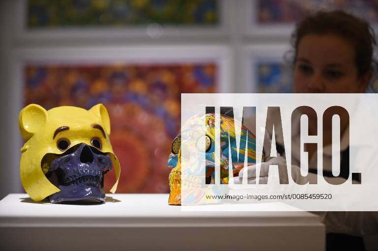 London, UJK - LONDON, UK. A technician inspects (L to R) Winnie The Pooh , 2005, by Gary Hume (Est. GBP400-600) and The Hours Spin Skull , 2009, by Damien Hirst (Est. GBP3,000-4,000) at a preview of the Yellow Ball: The Frank and Lorna Dunphy Collection sale at Sotheby s in New Bond Street. Frank Dunphy was Damien Hirst s former business manager and mentor. Over 200 works will be auctioned by Sotheby s on 20 September 2018. London UJK - ZUMAl94_ 20180914_zaf_l94_070