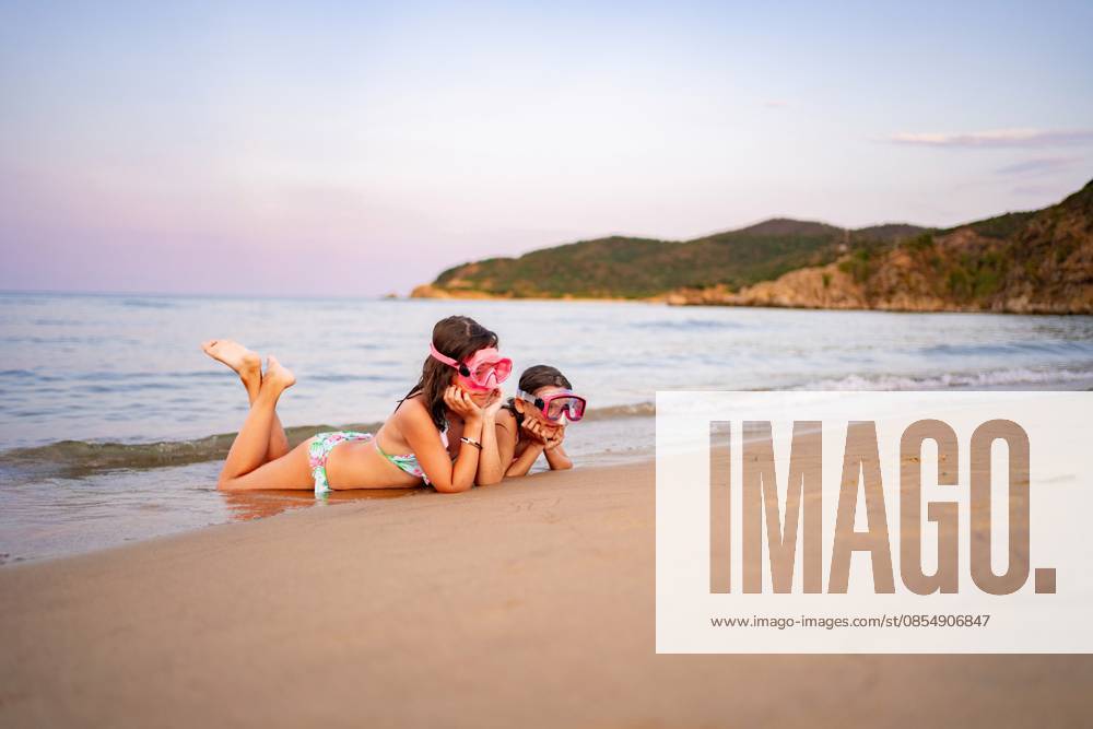 Die Familie genießt einen unterhaltsamen Tag am Strand und erkundet die Wellen Two children play at the shoreline, exploring the gentle waves and sand. (License=RF) ,model released, Symbolfoto