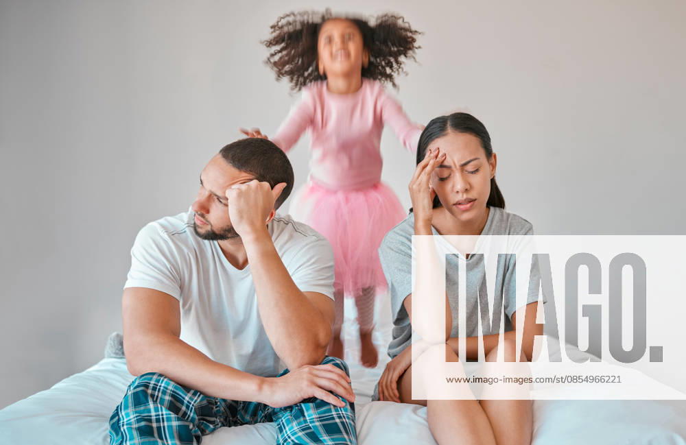 Stress, divorce and couple with a child on the bed with her parents in an argument or disagreement. Tired, break up and young angry mother and father with a adhd girl jumping in bedroom at their home. (License=RF) ,model released, Symbolfoto