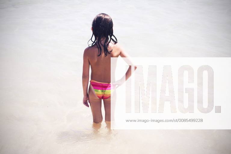 Little girl wading in the surf