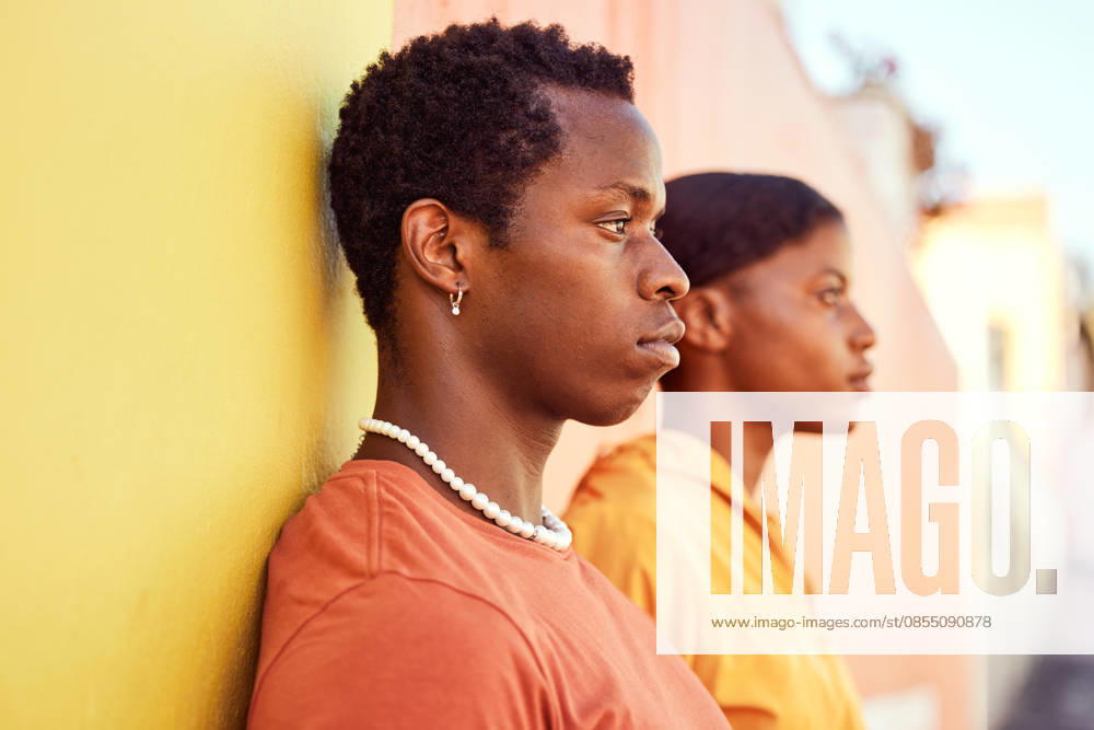 Urban fashion, African people and couple of friends relax with designer brand clothes, casual style and luxury apparel. Gen z aesthetic, color and profile of black woman and man on orange yellow wall. (License=RF) ,model released, Symbolfoto