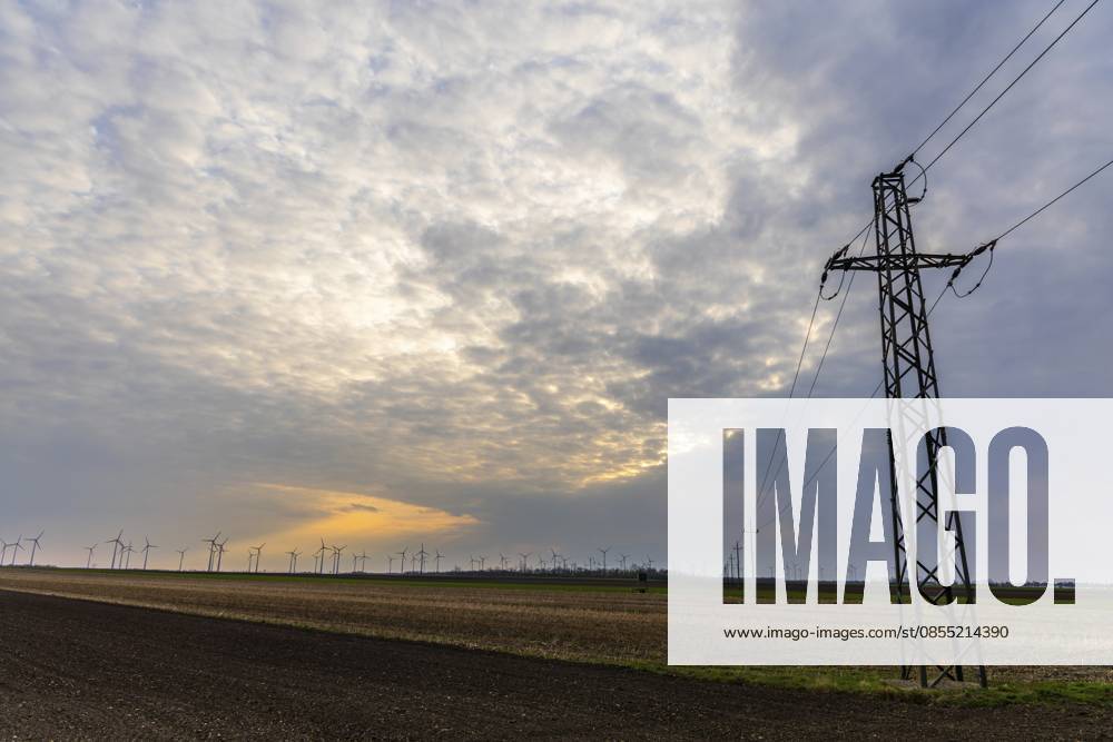 Morgenlicht und Wolkenstimmung, Ackerfläche, Strommast und Windräder in einem Windpark, bei Frauenkirchen, Nationalpark Seewinkel, Burgenland, Österreich Morning light and cloud atmosphere, arable land, power pole and wind turbines in a wind farm, near Frauenkirchen, Seewinkel National Park, Burgenland, Austria