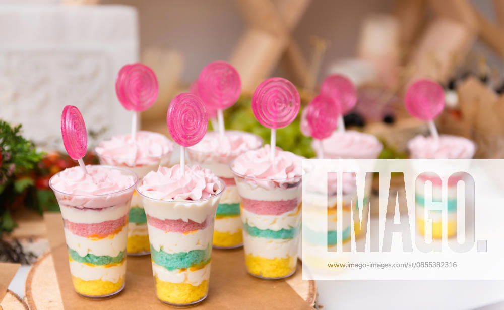 Glasbecher mit buntem Eis und Lutschern für einen Kinderfesttag Glass cups with colorful ice cream and lollipops for a children s holiday (License=RF)