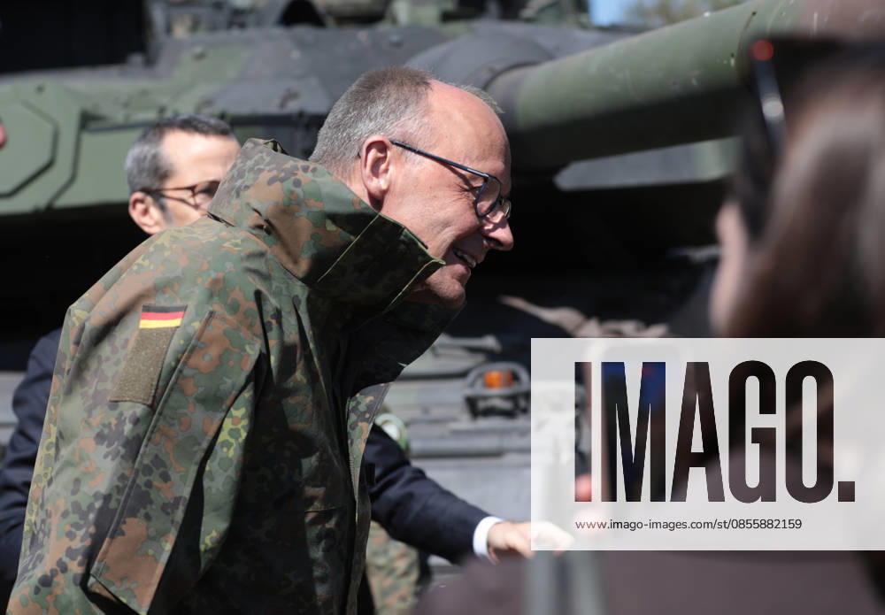 Bundeskanzler Friedrich Merz bei der Bundeswehr in Munster. Er senkt den Kopf vor einem Panzerrohr eines Leopard 2. Bundeskanzler Friedrich Merz bei der Bundeswehr in Munster. Er senkt den Kopf vor einem Panzerrohr eines Leopard 2. Munster Niedersachsen Deutschland