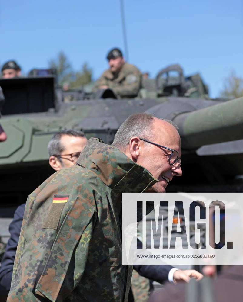 Bundeskanzler Friedrich Merz bei der Bundeswehr in Munster. Er senkt den Kopf vor einem Panzerrohr eines Leopard 2. Hochkant. Bundeskanzler Friedrich Merz bei der Bundeswehr in Munster. Er senkt den Kopf vor einem Panzerrohr eines Leopard 2. Munster Niedersachsen Deutschland