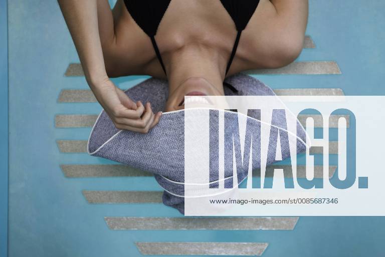 IMAGO Creative, Jahreszeit Sommer, Sonnenschutz Woman reclining poolside, concealing face with brim of sun hat