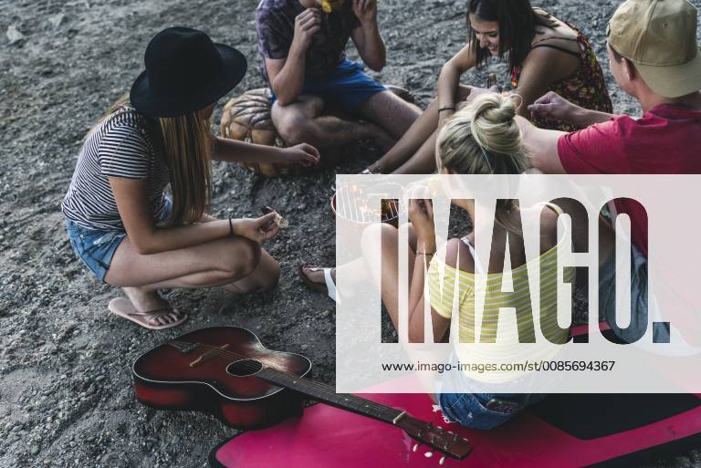 Group of friends sitting together having a barbecue model released Symbolfoto UUF14835