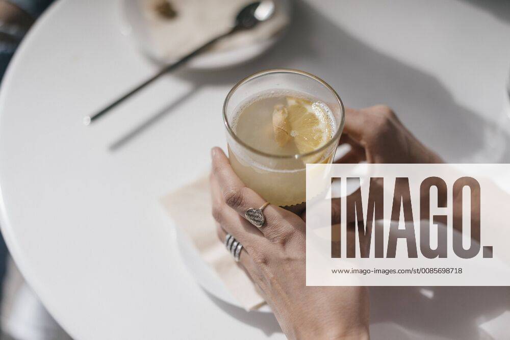 Woman holding glass of ginger lemon tea model released Symbolfoto property released JOSF02407