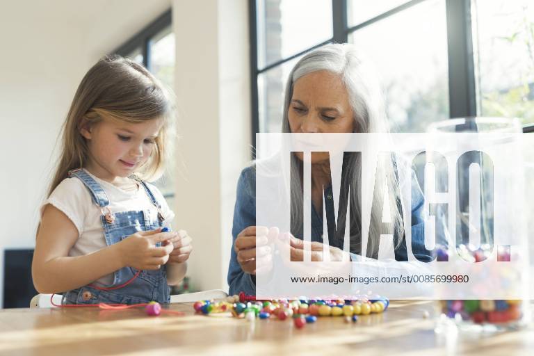 Grandmother and granddaughter threading beads model released Symbolfoto property released SBOF00574