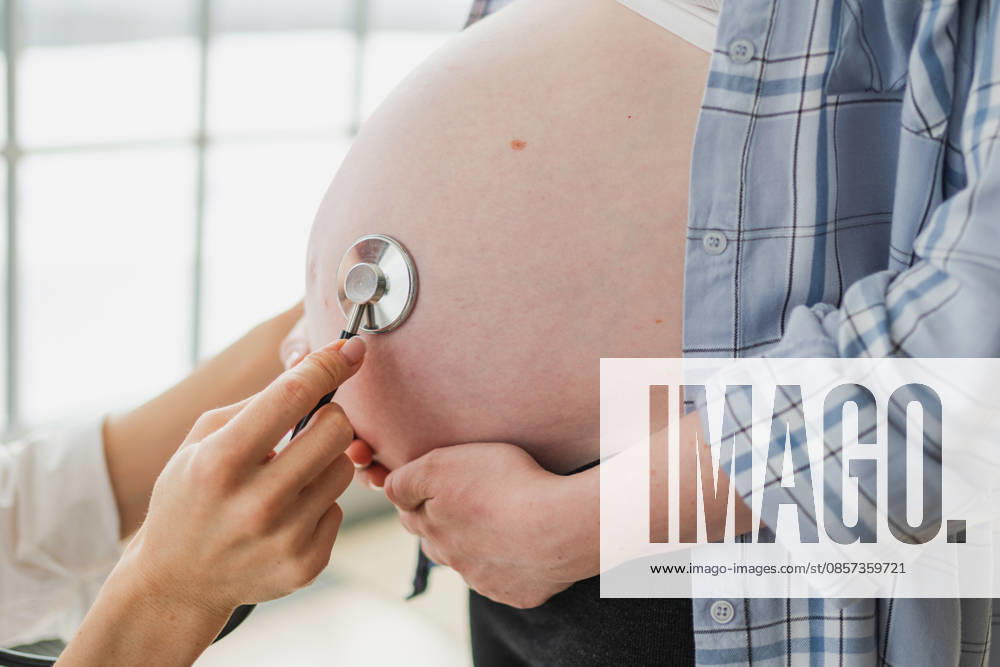 Arzt untersucht schwangere Frau hält Stethoskop in der Nähe von großen Bauch hören Baby Herzschlag. Gynäkologe Arzt Beratung Patientin über Schwangerschaft im Krankenhaus Büro. Besuch beim Arzt medizinischen Checkup. Doctor examining pregnant woman holding stethoscope near big belly listening baby heartbeat. Gynecologist doctor consulting patient about pregnancy in hospital office. Visit to doctor medical checkup (License=RF) ,model released, Symbolfoto