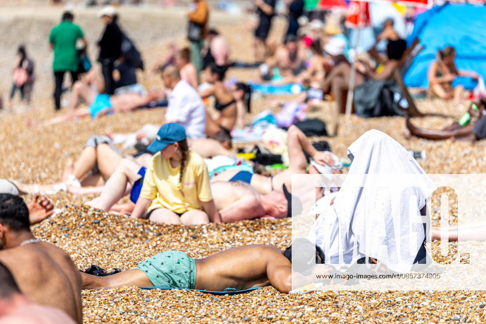 London, UK. Sun seekers enjoy the hot sun on Brighton Beach, East Sussex today as weather forecasters issue Amber weather warnings for high temperatures this Bank Holiday weekend. The Met Office has predicted a mini heatwave for the May Bank Holiday and school half term with temperatures expected to hit over 32c in London and the South East this week, possibly making it the hottest May on record. Brighton UK - ZUMAl94_ 20260523_zaf_l94_002