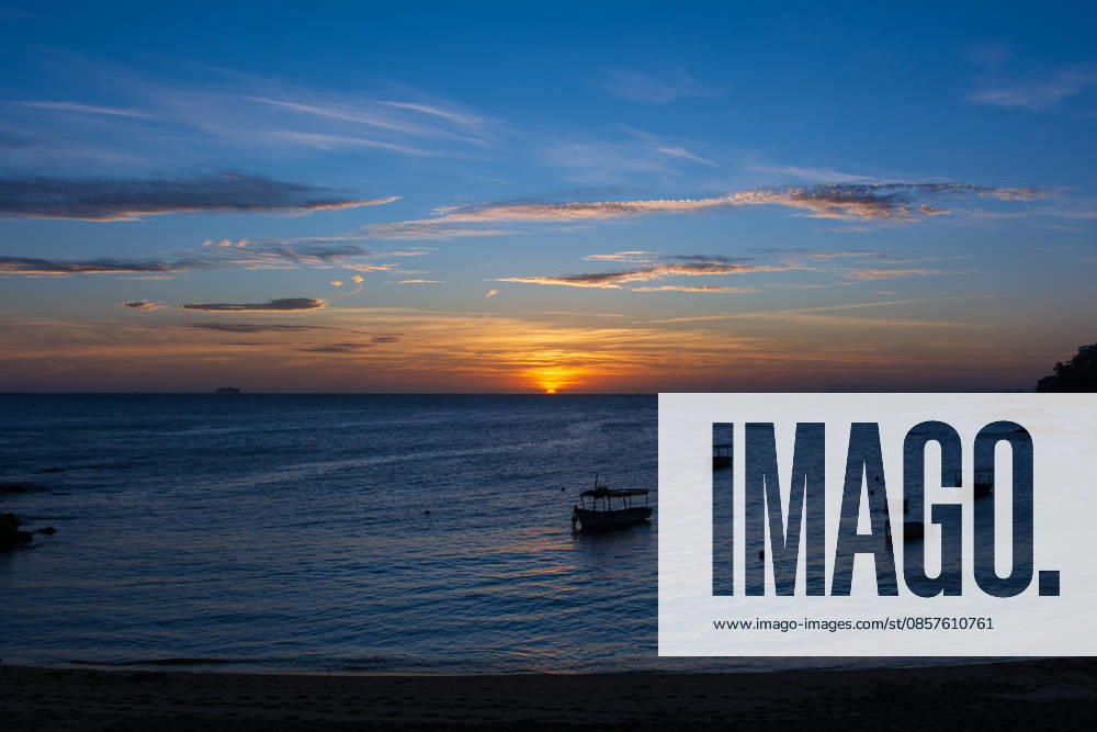 Boats anchored in calm seas during sunset, with a colorful sky and tranquil atmosphere on the Brazilian coast. Salvador Bahia Brazil