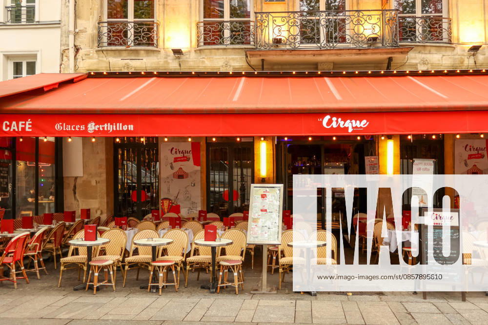 Paris, Frankreich. 13. Oktober 2025. Ein traditionelles französisches Café in Paris mit einer roten Markise, das Touristen zum Verweilen einlädt Paris, France. October 13, 2025. Parisian street cafe featuring a classic red awning and outdoor seating area for customers (License=RM)