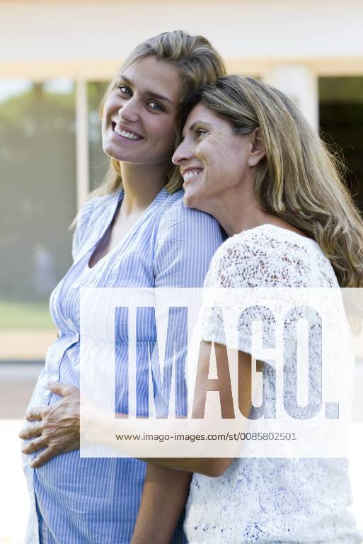 Mother putting hand on pregnant daughter s stomach