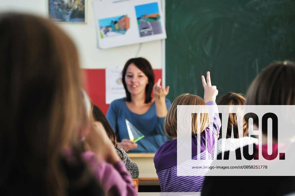 Happy young teacher woman at elementrary school teaching and giving leassons to group of young smart children model released Symbolfoto