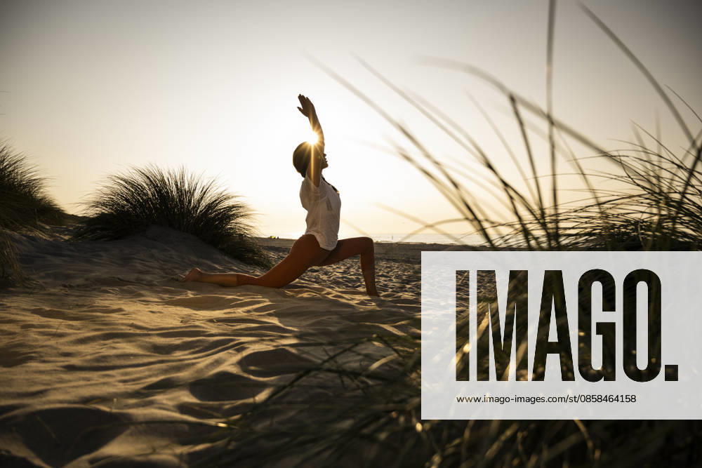 Woman practicing yoga on a sandy beach at sunset model released, Symbolfoto, UUF36838