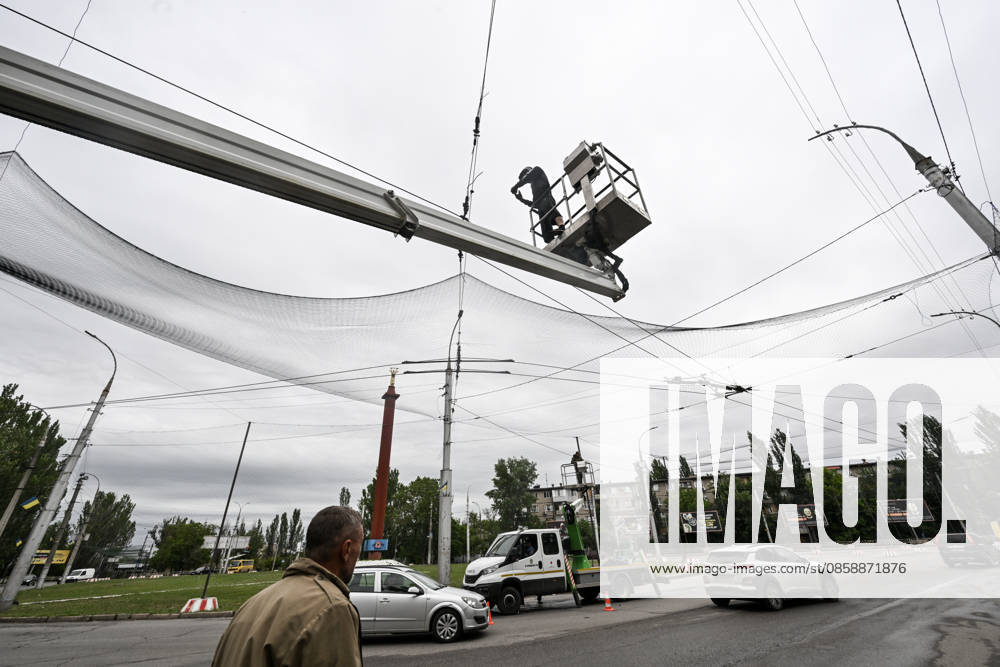 A municipal worker installs anti-drone netting to protect against Russian FPV drones in the yellow zone of the frontline city of Kherson, Ukraine, on June 3, 2026. The Russian army attacks the city daily with FPV drones and other unmanned aerial vehicles, deliberately terrorizing civilians. Russian forces conduct hunts for local residents, tracking them with FPV drones and dropping explosives. Police officers, medics, public transport, and urban infrastructure are also targeted. Based on the intensity of attacks, Kherson is informally divided into yellow and red zones, with the red zone being the most dangerous due to constant shelling and drone strikes (Photo by Dmytro Smolienko Ukrinform) Life under shelling in frontline Kherson