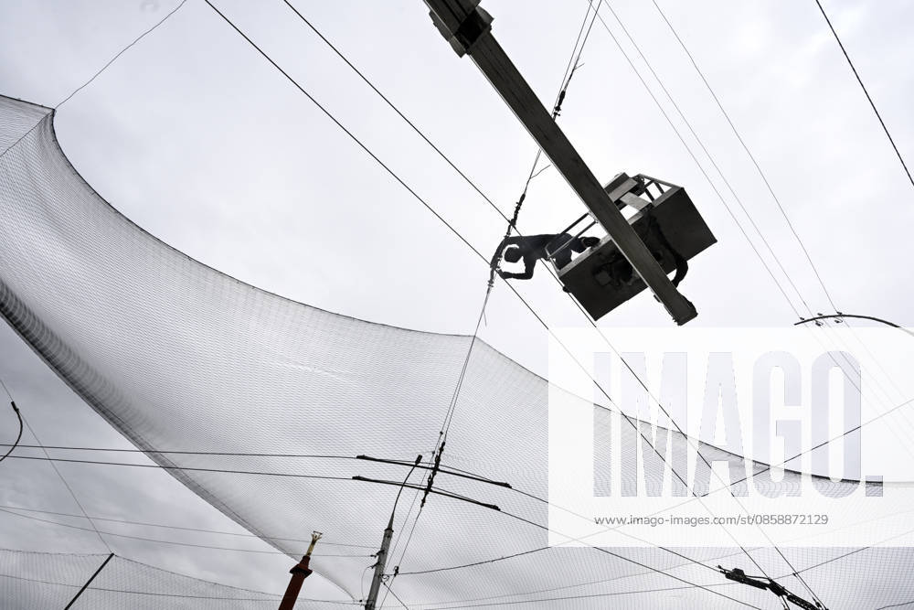 A municipal worker installs anti-drone netting to protect against Russian FPV drones in the yellow zone of the frontline city of Kherson, Ukraine, on June 3, 2026. The Russian army attacks the city daily with FPV drones and other unmanned aerial vehicles, deliberately terrorizing civilians. Russian forces conduct hunts for local residents, tracking them with FPV drones and dropping explosives. Police officers, medics, public transport, and urban infrastructure are also targeted. Based on the intensity of attacks, Kherson is informally divided into yellow and red zones, with the red zone being the most dangerous due to constant shelling and drone strikes (Photo by Dmytro Smolienko Ukrinform) Life under shelling in frontline Kherson