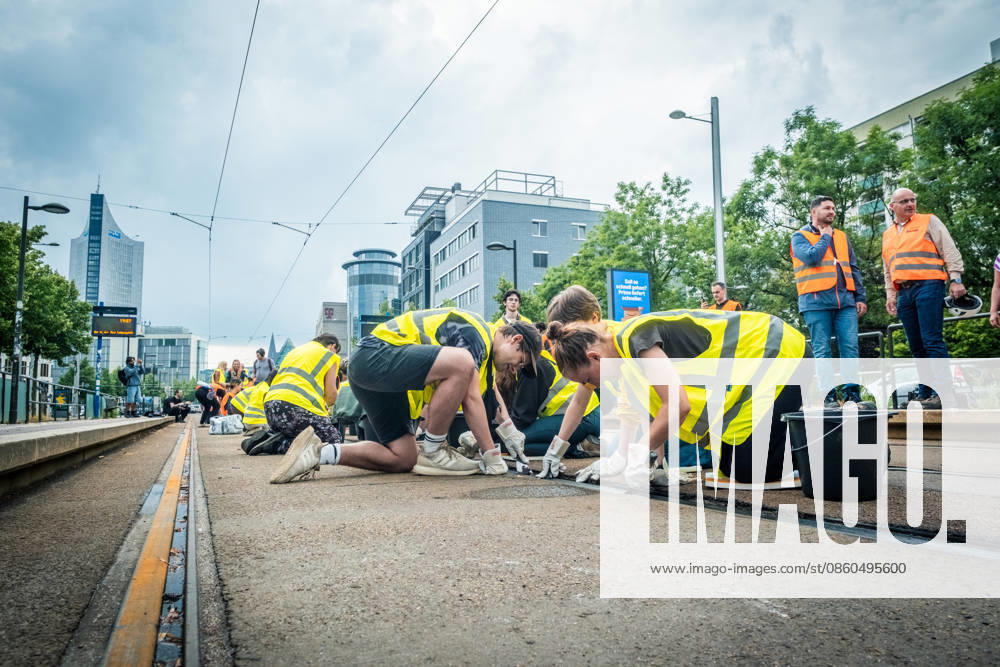 Leipziger Bürgerinnen und Bürger befreien am Johannisplatz gemeinsam mit den Leipziger Verkehrsbetrieben (LVB) die Straßenbahngleise von geschmolzenem Bitumen. Nachdem bereits am Vortag rund 100 Freiwillige einem Aufruf der LVB gefolgt waren, wurden die Reinigungsarbeiten am zweiten Tag am Johannisplatz fortgesetzt. Hintergrund sind die Schäden durch die extremen Temperaturen des vergangenen Hitzewochenendes. Aufnahme vom Datum . Reinigung Leipzig