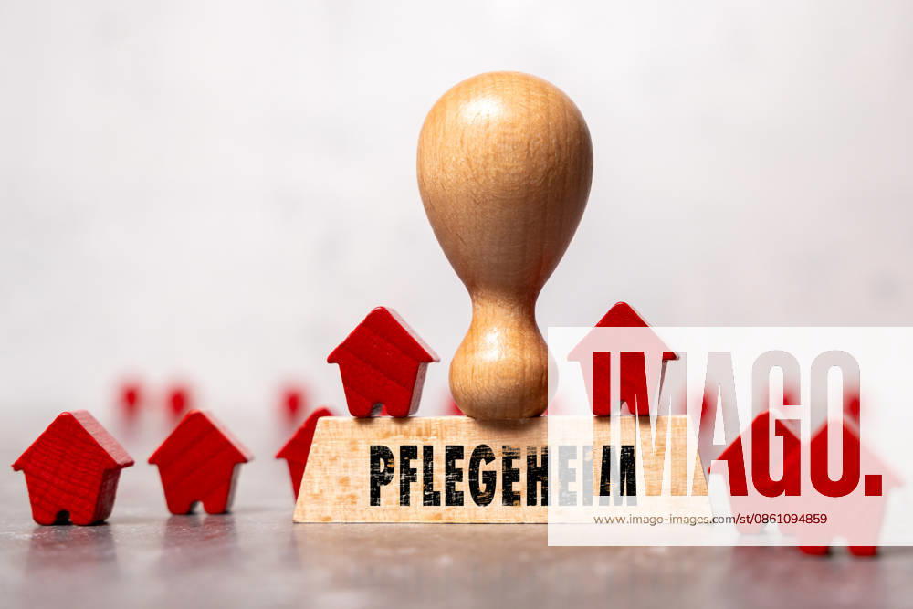 FOTOMONTAGE, Ein Holzstempel mit der Aufschrift Pflegeheim zwischen kleinen Holzhäusern symbolisiert stationäre Pflege und Seniorenwohnen. Das Motiv steht für Pflegeplätze, Betreuung, Demografiewandel und Pflegepolitik.